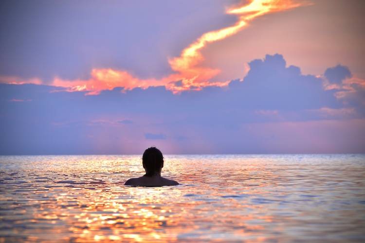 Man swimming in the Gulf during sunset